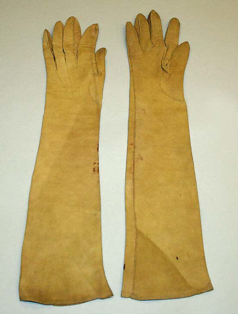Fawn-colored, elbow-length leather gloves.