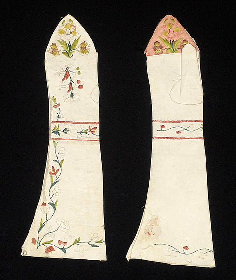 White leather fingerless gloves embroidered with flowers and leaves.