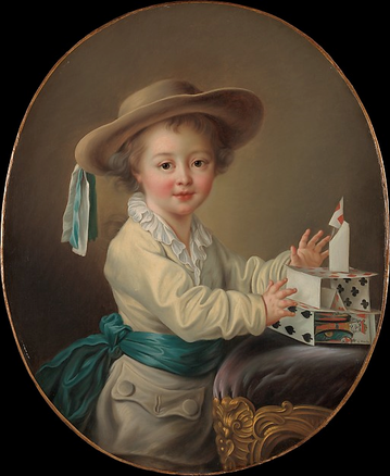 Young boy in a white suit, medium blue sash, and straw hat decorated with blue and white ribbons looks toward the viewer. His attention has been diverted from a house of cards he has built on the top of an ottoman upholstered in purple velvet.
